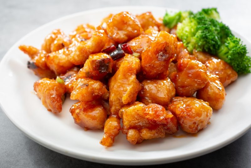 a plate of orange chicken and broccoli